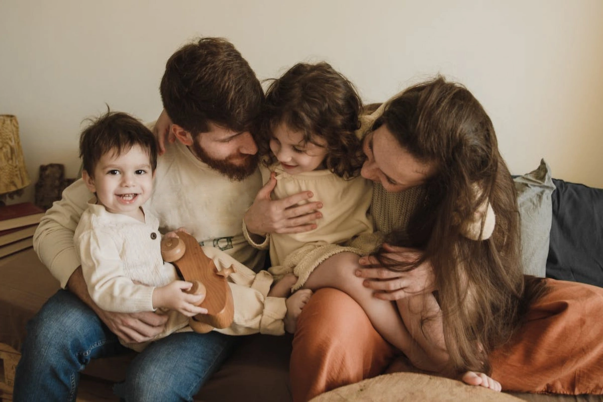 parents sitting on the couch with two young children